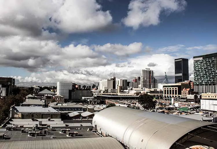 Landscape photo from the roof of a building looking over a rustic coloured cityscape.